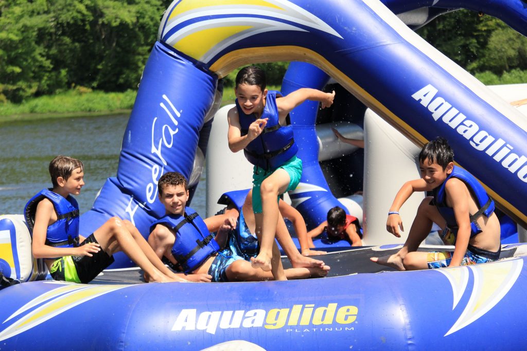 Kids choosing to play on a trampoline on the lake at Camp Lindenmere Summer Camp